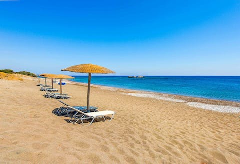 Walk to Kiotari beach and relax on a sun bed as the waves roll in
