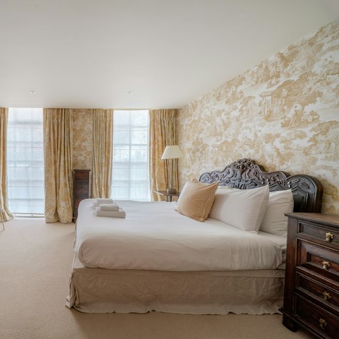Admire the pretty patterned wallpaper before falling into bed