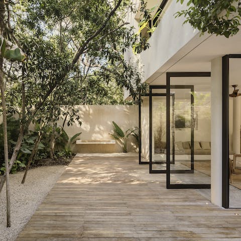 Blend indoor and outdoor living by opening up the floor-to-ceiling glass doors