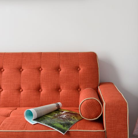 Snuggle up on the bright orange sofa with a good book