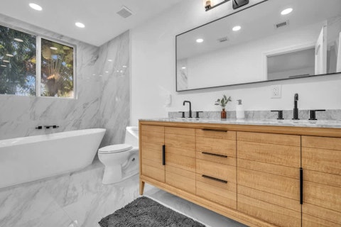 Freshen up in a spacious bathroom with serene greenery just outside the window