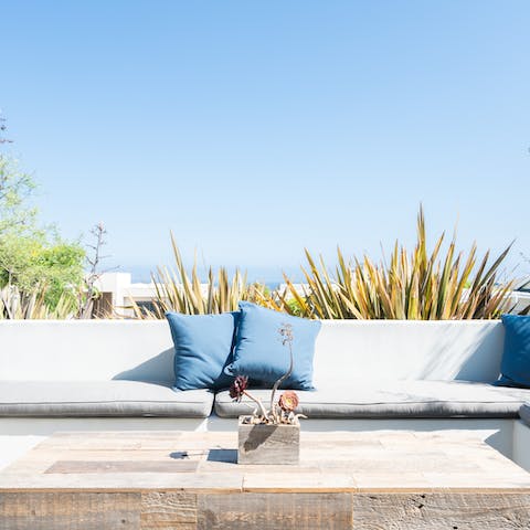 Sunbathe on the sundeck with sea views at Toponga Beach behind you