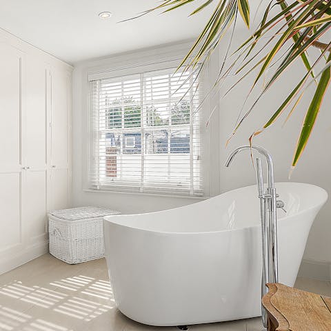 Treat yourself to an indulgent bubble bath in the sleek freestanding tub