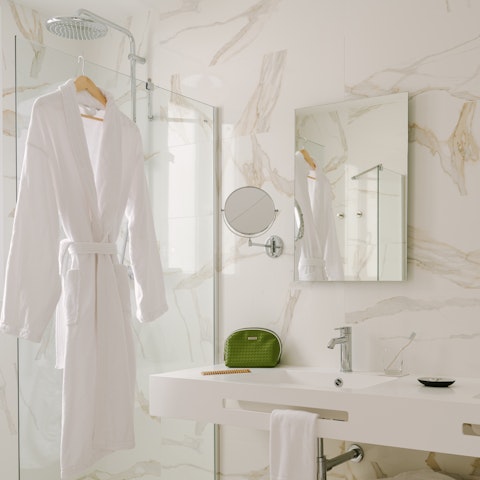 Feel anew beneath the rainfall shower of the slick, marble-clad bathroom
