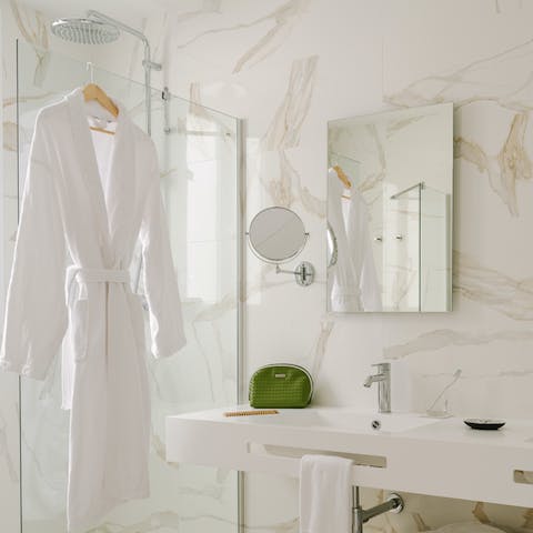 Feel anew beneath the rainfall shower of the slick, marble-clad bathroom