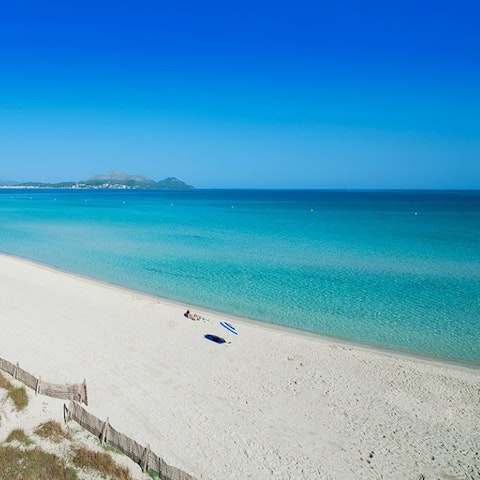 Sink your toes into the sand of Can Cap de Bou Beach, a short drive away