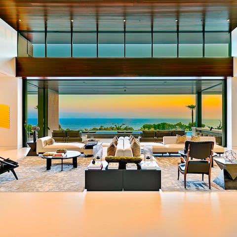 Entertain in style in the vast living space with its double-height windows and dramatic sea views