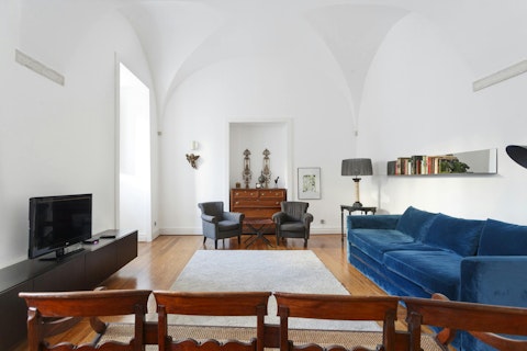 Gather in a living room with soaring historic vaulted ceilings