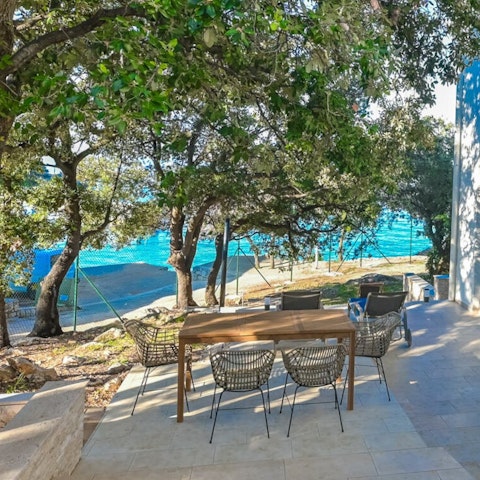 Sit out on the shady stone terrace overlooking the beach