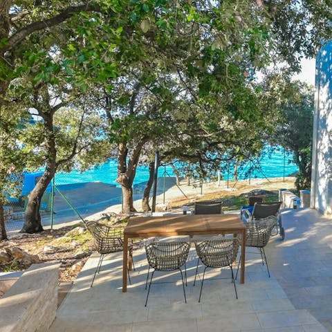 Sit out on the shady stone terrace overlooking the beach