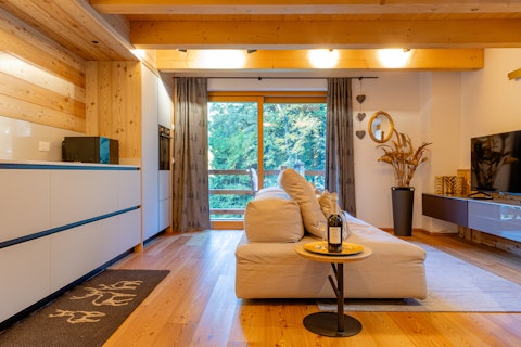 Unwind in a warm living space with forest views beyond the balcony