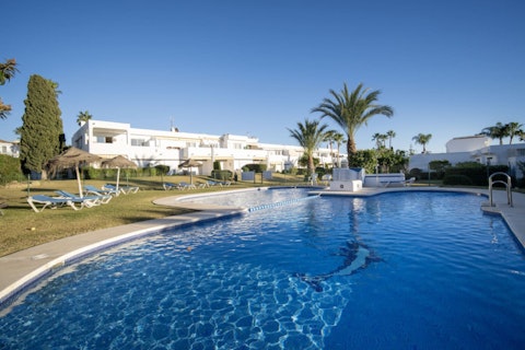 Stretch out beside the communal pool set in manicured grounds