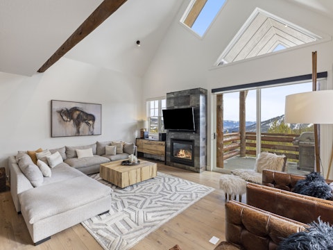 Sink into the sofa beside a glowing fireplace with mountain views