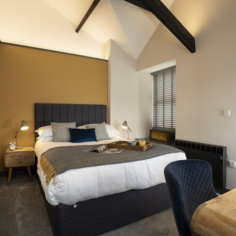 Unwind in the serene bedroom with a plush bed and high vaulted ceiling