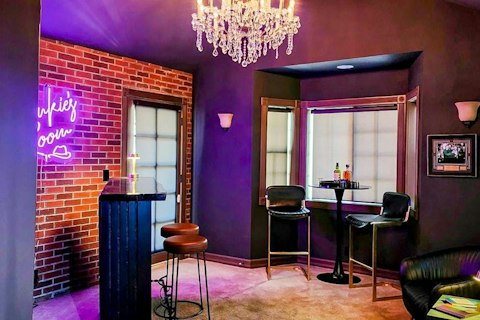 Mix drinks in a vibrant, neon-lit bar room after dark