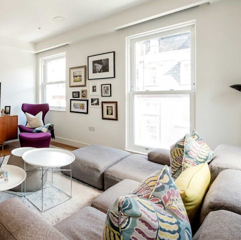 Cosy up on the sofa while taking in Central London views from the living room's tall windows
