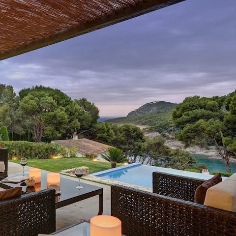 Sip your evening drink with views of the pool and sea