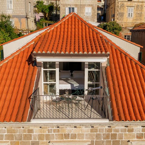 Retire to the bedroom balcony to watch a romantic sunset over a warm-hued townscape