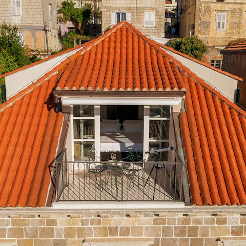 Retire to the bedroom balcony to watch a romantic sunset over a warm-hued townscape
