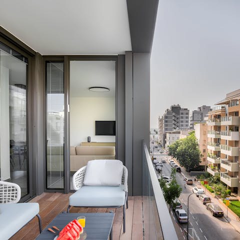 Watch the leafy boulevards bustle below from the balcony