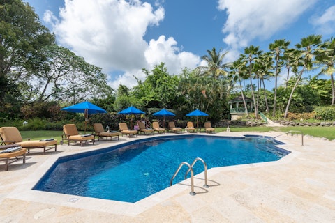 Cool off in the pool framed by lush tropical grounds