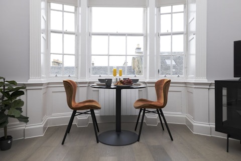 Breakfast beside period sash windows overlooking Edinburgh's stone rooftops