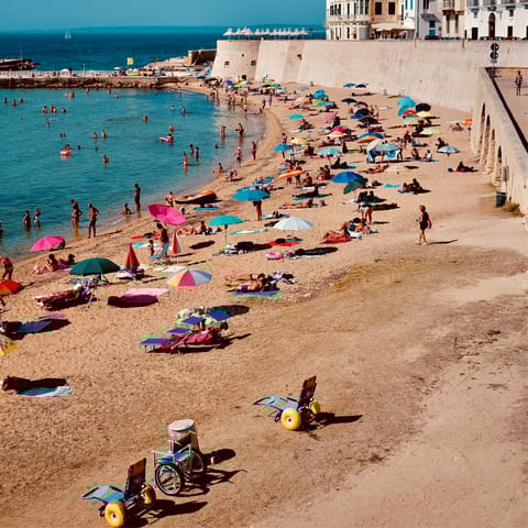 Visit the cute beach lined with colourful umbrellas, just a short walk away