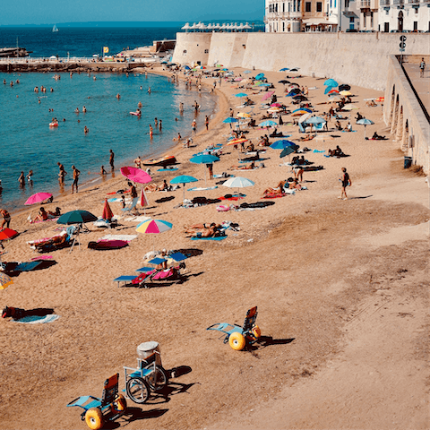 Visit the cute beach lined with colourful umbrellas, just a short walk away