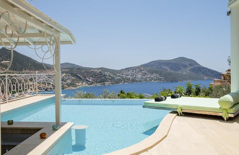 Sit on the sunken stool at the swim up bar, drinking a cocktail as you take in the view