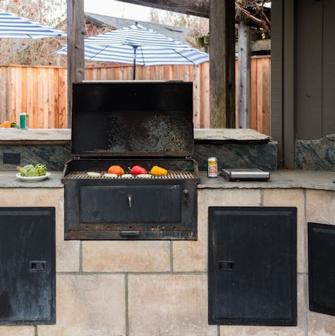 Cook up a hearty meal to enjoy by the pool with this alfresco dining area