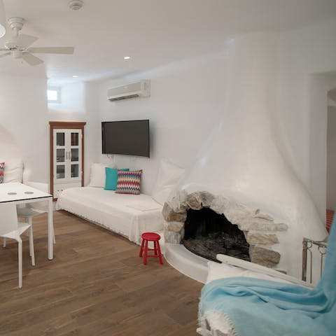 Admire traditional Cycladic touches like the old stone fireplaces