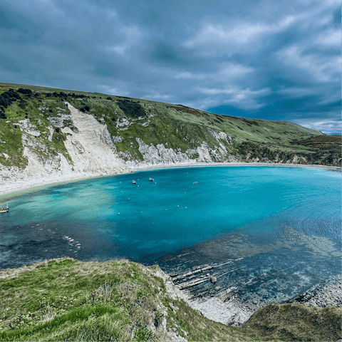 Swim in the crystal-clear waters of Lulworth Cove, just a short drive away