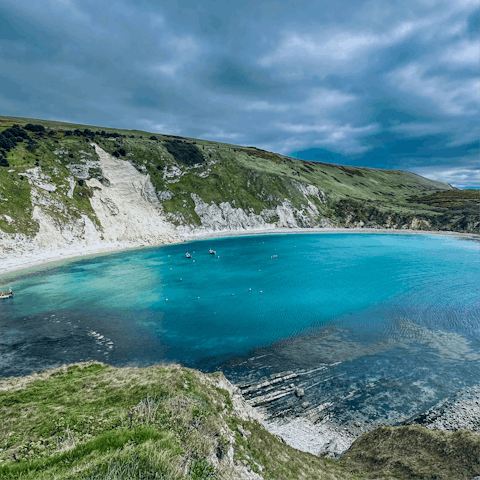 Swim in the crystal-clear waters of Lulworth Cove, just a short drive away