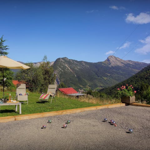 Play pétanque with a backdrop of mountains