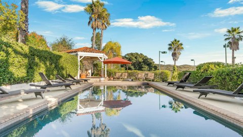 Stretch out on a sun lounger beside the glassy pool