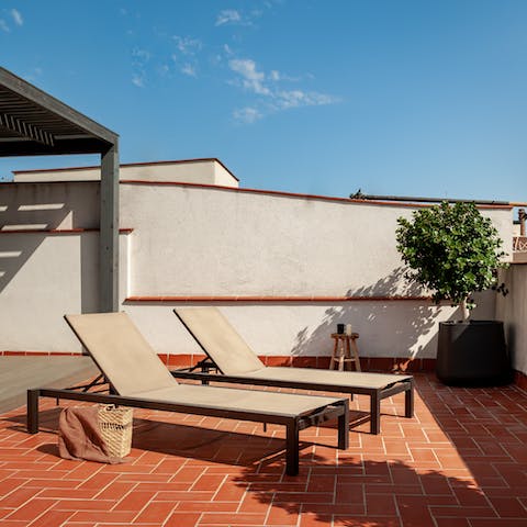 Catch some rays on the shared terrace's deck chairs