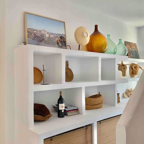 Admire the collection of sea-glass bottle and driftwood artwork