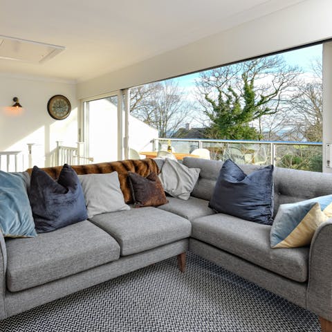 Recline on the L-shaped sofa as a gentle breeze drifts through the home