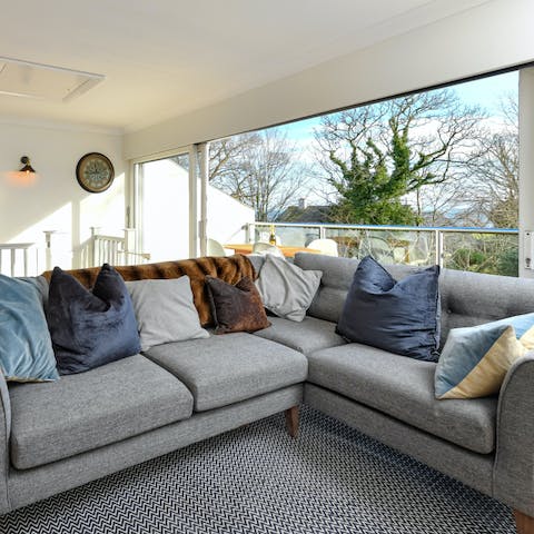 Recline on the L-shaped sofa as a gentle breeze drifts through the home