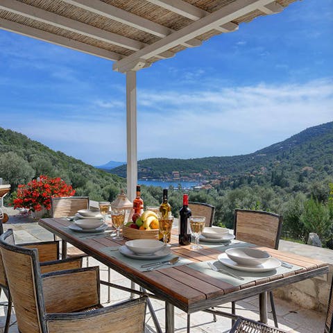 Dine alfresco on the covered poolside terrace while admiring gorgeous Greek views