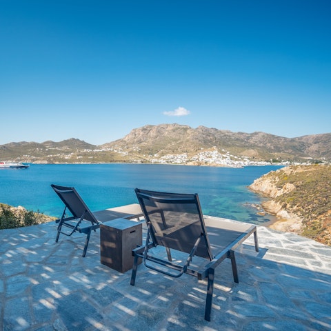 Stretch out in the sun with views across the Aegean Sea