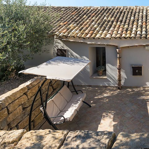 Stretch out on the swinging seat, catching up on your holiday read