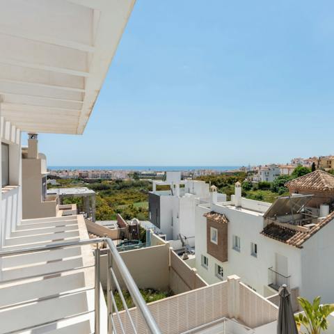 Peer over your private balcony to spot the sea in the distance