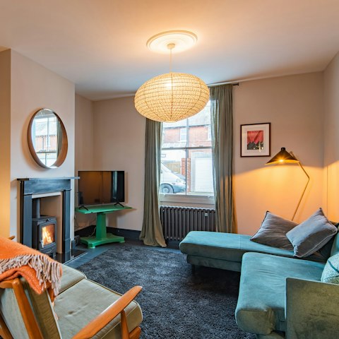 Snuggle up by the living room's fire, a glass of wine in hand