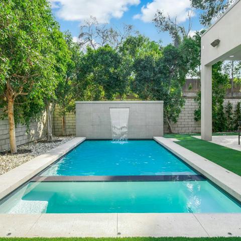 Stand underneath the swimming pool's waterfall before warming up in the hot tub