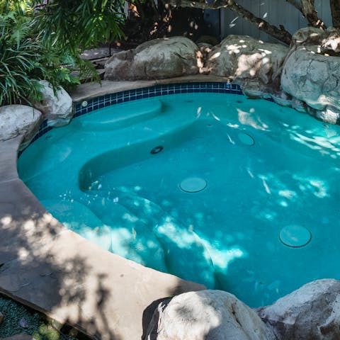 Cool down or warm up on the backyard spa jacuzzi – there's room for all thirteen of you