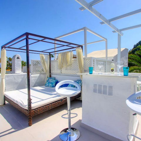 Strech out in the sunshine on the double day bed on the rooftop