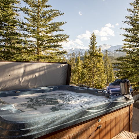 Unwind in the hot tub and take in the mountain view between the trees