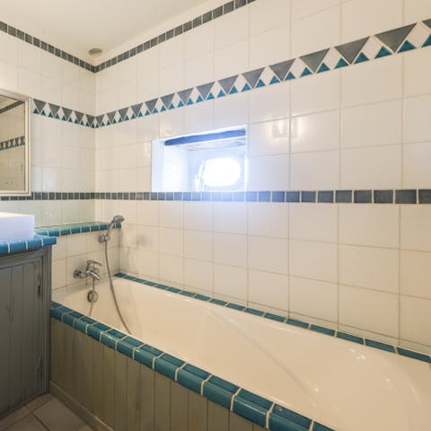 Finish the day with a rejuvenating soak in the tiled bathtub