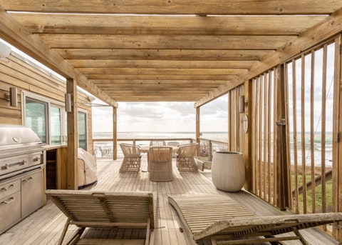 Grill alfresco as waves break just beyond the deck rail